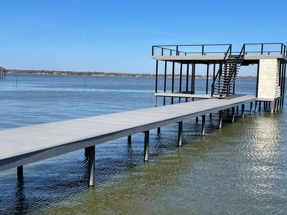 Side angle of a custom double layered deck with stairs pictured on the water