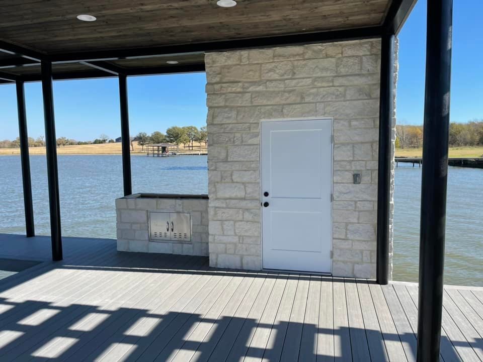 Custom deck with a door leading to a supply closet of some sort and a side grill area