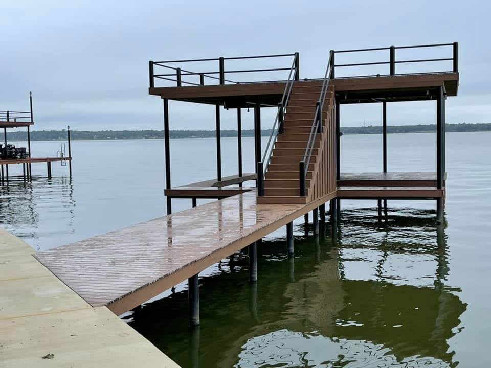 Another angle of a dock pictured on the water with stairs in a brown color